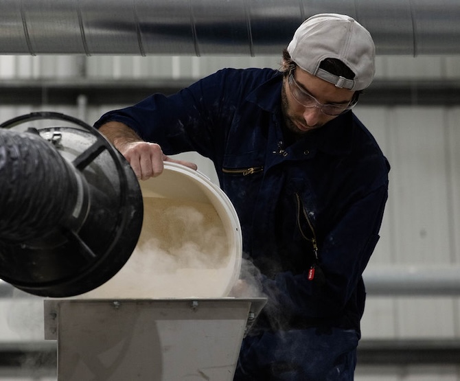 Operator pouring powder into a doser